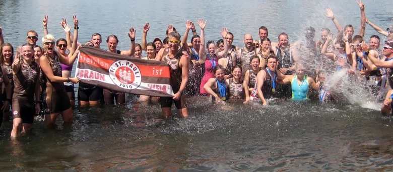 Man sieht die Triathlon Mannschaft im Wasser