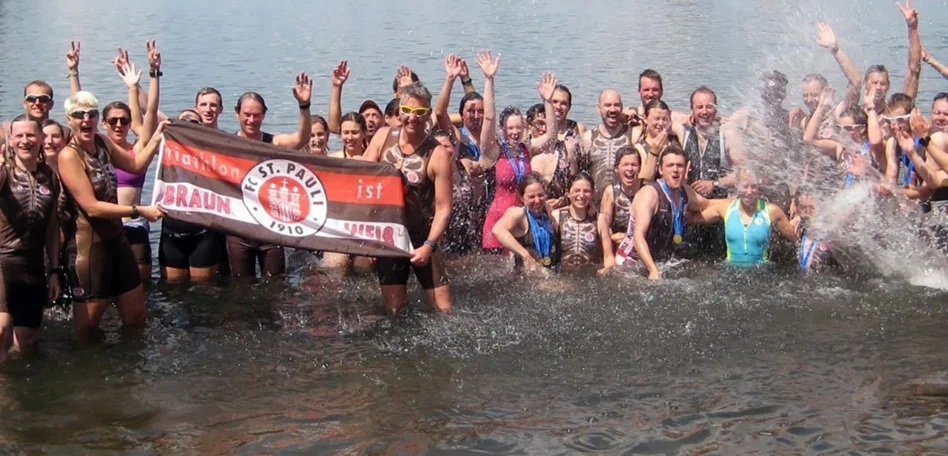 Man sieht die Triathlon Mannschaft im Wasser