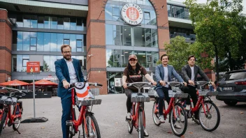 Anjes Tjarks, Esin Rager, Cornelius Kiermasch und Wilken Engelbracht sitzen jeweils auf einem StadtRAD, im Hintergrund ist das Millerntor-Stadion zu sehen.