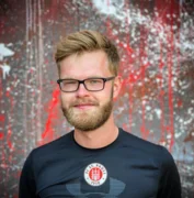 Dennis Blum von FUNiño. Er ist blond und trägt sowohl Brille als auch Bart.