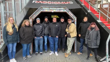 Eine Gruppe von Menschen stehen vor einem Banner, auf dem das Wort "Rassismus" durchgestrichen ist.