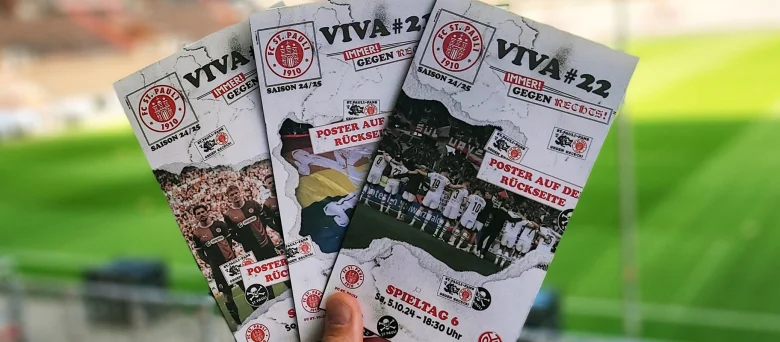 Es werden drei Flyer für ein St. Pauli Spiel wie ein Fächer hochgehalten