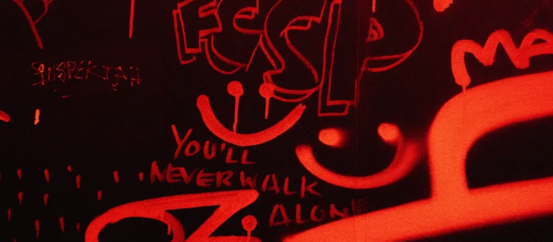 Eine schwarze Wand mit roten FCSP Graffiti