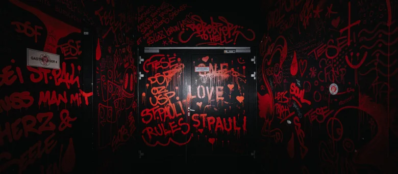 Ein schwarzer Gang mit vielen roten St Pauli Graffiti
