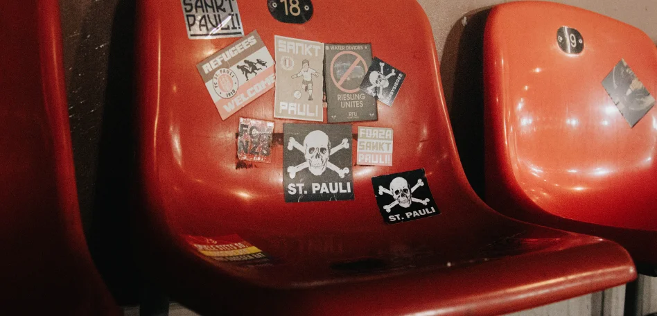 Ein roter, mit Stickern beklebter, Stadionstuhl