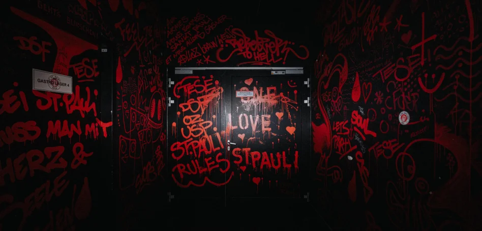 Ein schwarzer Gang mit vielen roten St Pauli Graffiti