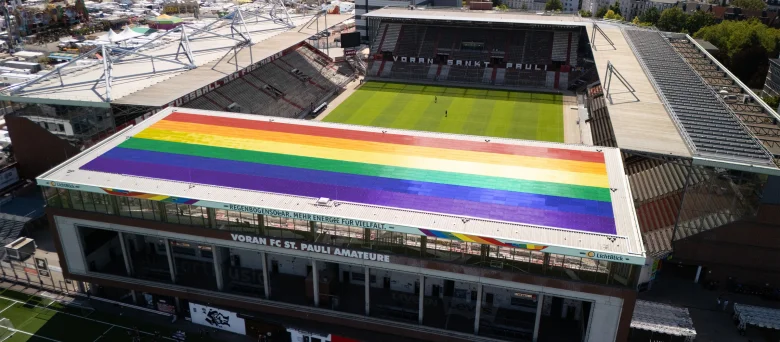 Eine Luftaufnahme vom Millerntor-Stadion, dabei ist die in Regenbogenfarben versehene Solaranlage auf der Nordtribüne zu sehen.