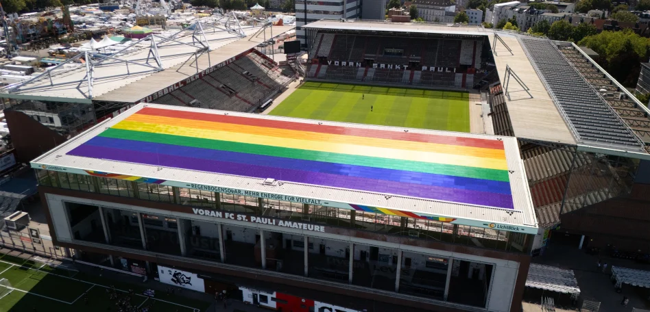 Eine Luftaufnahme vom Millerntor-Stadion, dabei ist die in Regenbogenfarben versehene Solaranlage auf der Nordtribüne zu sehen.