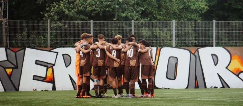 Das Bild zeigt ein Team des FC St. Pauli Nachwuchsbereichs im Kreis stehend.