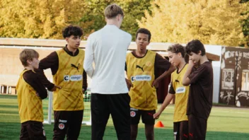 Ein Coach erklärt den Nachwuchsspieler:innen etwas