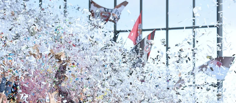 FC. St. Pauli Fans wedeln mit Flaggen, drumherum fliegt weißes Konfetti