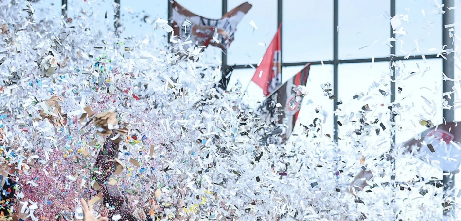 FC. St. Pauli Fans wedeln mit Flaggen, drumherum fliegt weißes Konfetti