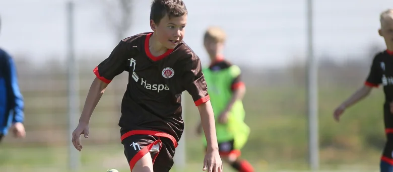Jungs, die an einem Powercamp teilnehmen und Fußball spielen