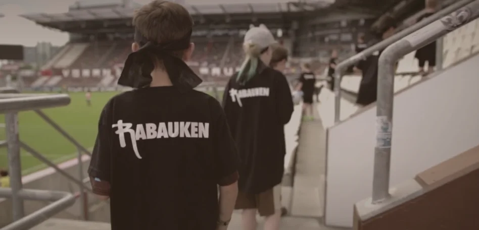 Rabauken sind im Millerntor-Stadion. Man sieht sie von hinten, sie tragen ein Rabauken-Tshirt.