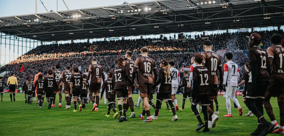 Man sieht die Mannschaft mit den Rabauken Einlaufkindern ins Stadion einlaufen