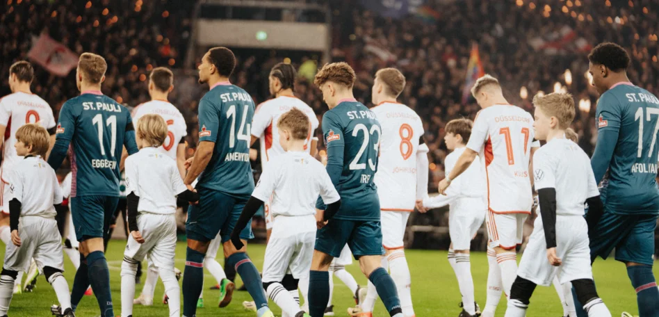 Man sieht die Mannschaft mit den Einlaufkindern einlaufen.