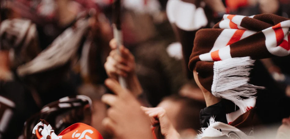 Man sieht die Hände von Menschen im Stadion mit FCSP Fahnen