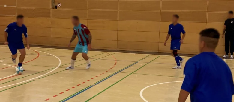 Man sieht Personen auf einem Basketball-Court.