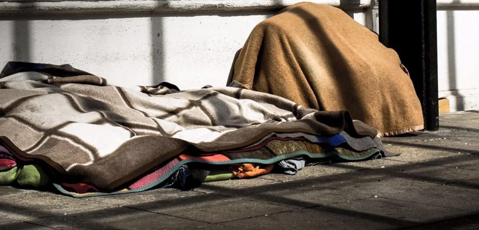 Man sieht Obdachlose schlafend auf der Straße.