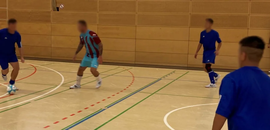 Man sieht Personen auf einem Basketball-Court.